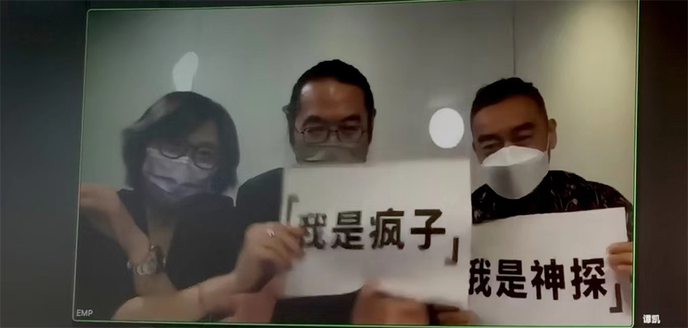 Wei Jiahui (middle) holds a sign "I am a lunatic", and Liu Qingyun holds a sign "I am a detective". Photography Wang Zhen