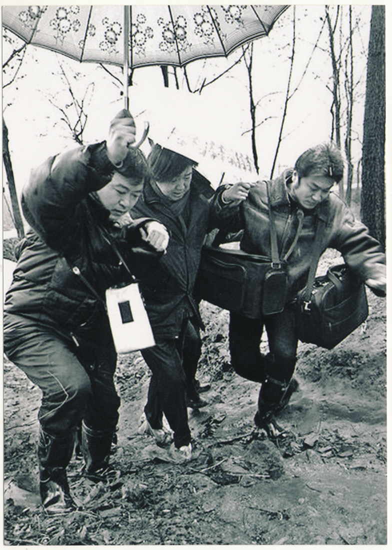 Feng Jicai (middle) entered the village in the rain to investigate the New Year pictures in Hua County, Henan