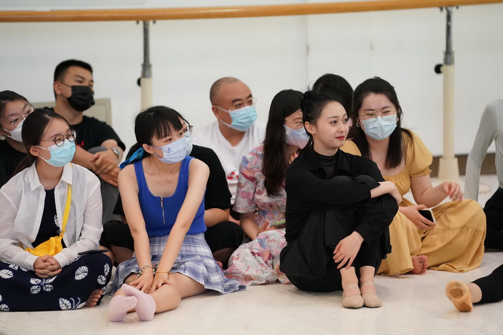 Dancers and visiting audience sit on the floor