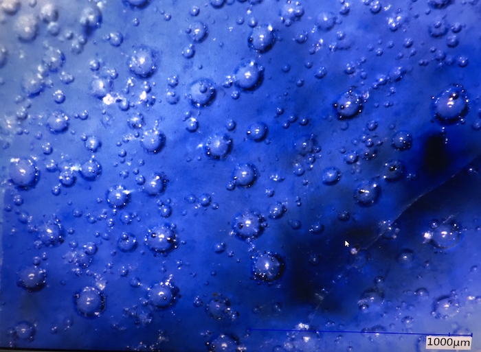 Blue and white porcelain made in Xuande year showing air bubbles under the microscope